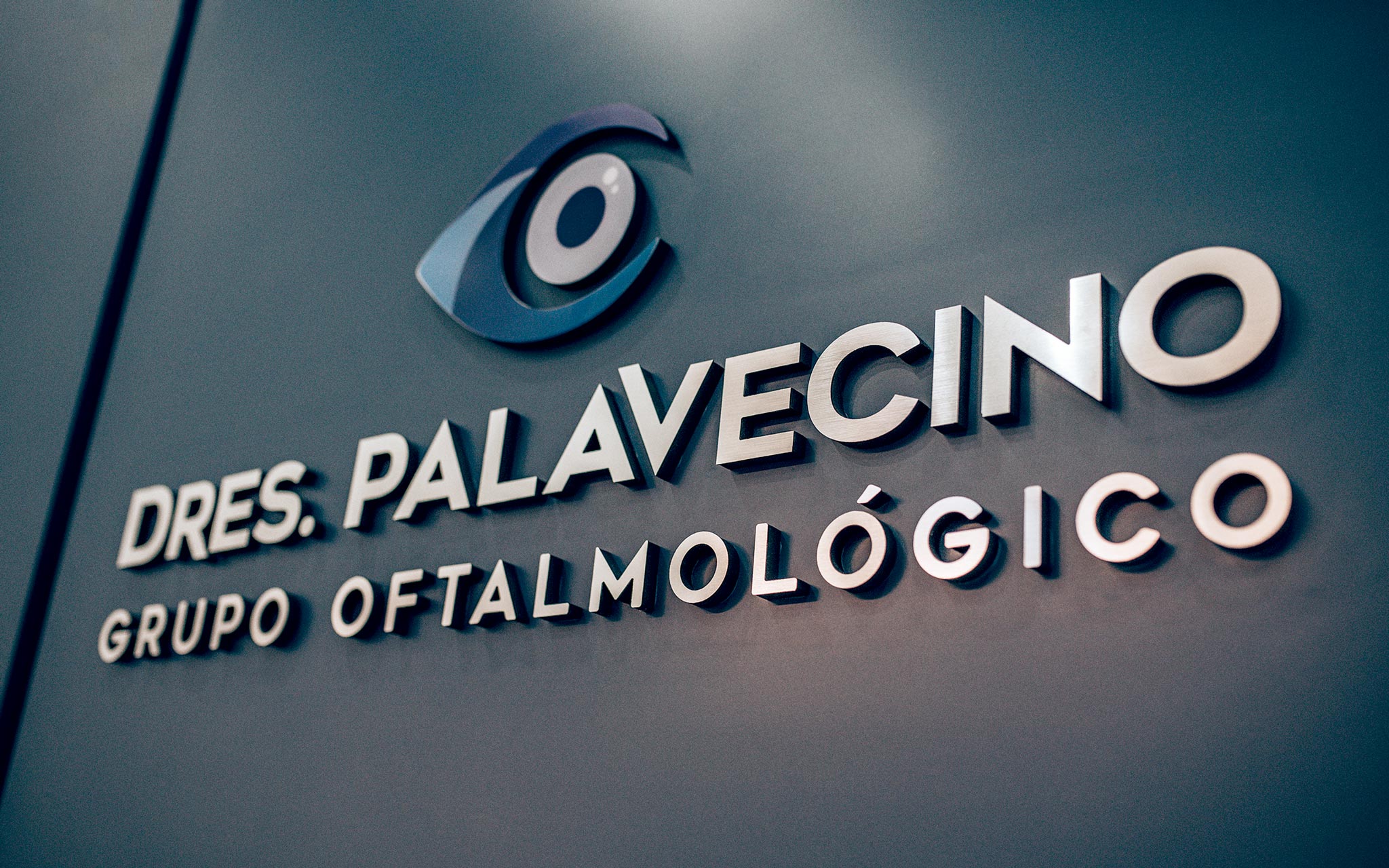 Letrero en una pared con el nombre Dres. Palavecino Grupo Oftalmológico acompañado de un logotipo con la forma de un ojo estilizado.